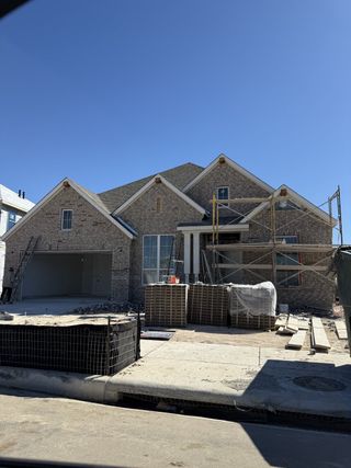 A modern brick home under construction in Santa Rita Ranch: 60ft. lots by Highland Homes (Liberty Hill, TX).