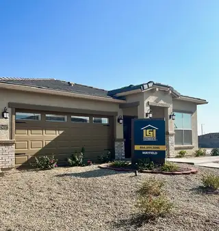 Charming beige home with a neat rock landscape in Mayfield by LGI Homes, Buckeye, AZ.