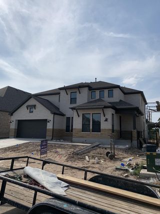 A modern two-story home with large windows and a spacious garage in Santa Rita Ranch by Taylor Morrison (Liberty Hill, TX).