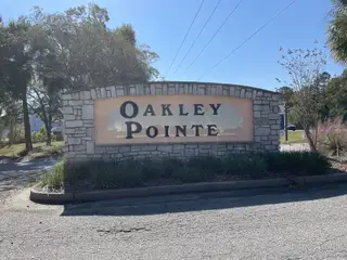 Charming entrance with a stone sign welcoming you to Oakley Pointe by Eastwood Homes in Moncks Corner, SC.