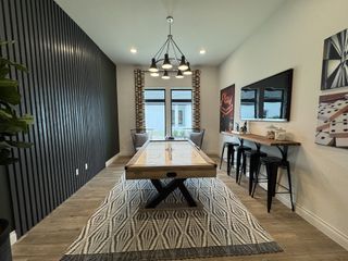 Model Home A stylish game room with wood paneling, modern lighting, and a bar area in Vista Alta Del Veramendi by Perry Homes (New Braunfels, TX).