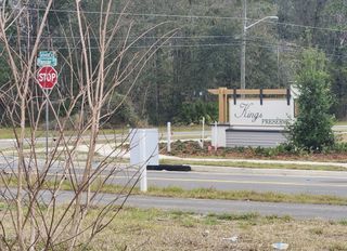Street view A welcoming entrance to Kings Preserve by Breeze Homes, nestled in Jacksonville, FL, surrounded by lush greenery and scenic views.