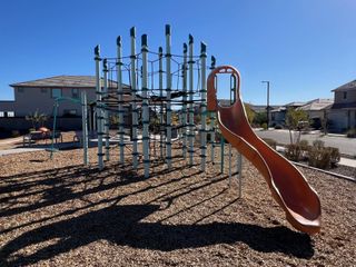 A vibrant playground with climbing structures and slides in Mason Ranch ll by D.R. Horton, nestled in Surprise, AZ.