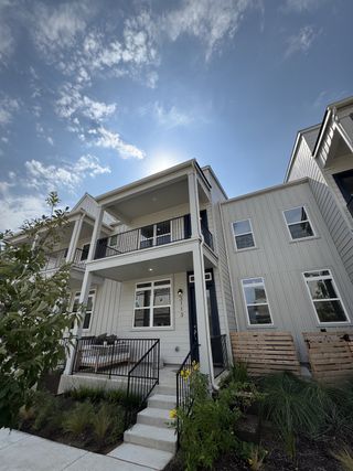 Street view A modern two-story home with sleek railings and a small patio in Mueller 11 - 22.5 X 90 Row Home by Lennar (Austin, TX).