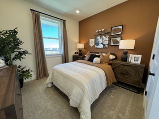 A cozy bedroom featuring earth-tones, baseball-themed decor, and warm lighting with a scenic window view.