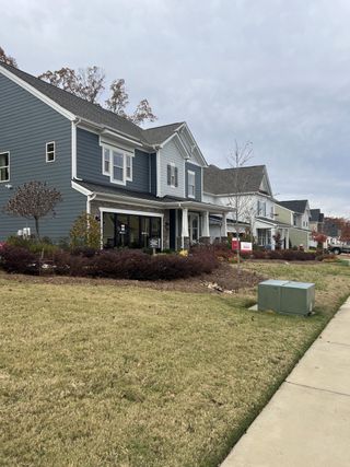 A charming blue and gray home with manicured landscaping in Stafford at Langtree by Taylor Morrison (Mooresville, NC).