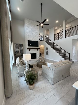 Model Home Open-concept living space with tall windows, neutral tones, and a cozy fireplace.