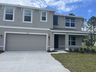A modern gray two-story home with a landscaped yard in Ocala Crossings South by D.R. Horton (Ocala, FL).