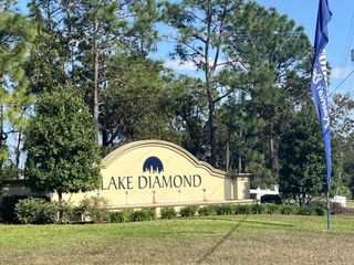 A welcoming entrance sign with lush greenery at Lake Diamond by D.R. Horton in Ocala, FL.