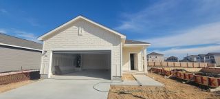 Street view A charming new-build home with a clean white facade and garage in Sutton Farms by Starlight Homes (San Antonio, TX).
