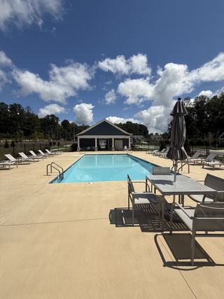 A sleek community pool with lounge chairs and a pavilion in Candleberry Place by Lennar (Sharpsburg, GA).