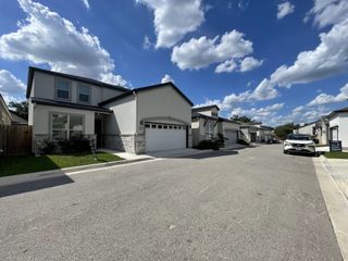 Modern homes with stone accents and manicured lawns in The Crest at Elm Creek by Tirol Homes (San Antonio, TX).