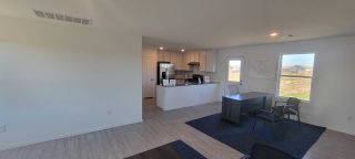 Model Home A bright, open-concept kitchen with sleek cabinets and modern appliances, featuring a cozy dining area with abundant natural light.