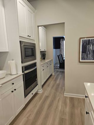 A butler’s pantry with ample storage and white cabinetry in Kingston by DRB Homes (Locust Grove, GA).