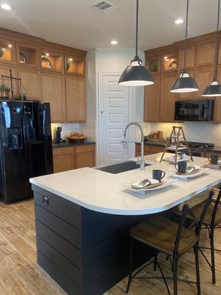 A modern kitchen with a sleek island, pendant lighting, and warm wooden cabinetry, perfect for entertaining.