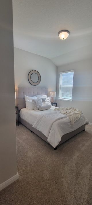A cozy bedroom featuring a plush bed, soft lighting, and a decorative mirror on a neutral palette.