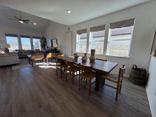This home features an open-concept dining and living space with ample natural light streaming in through multiple windows.
