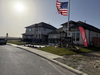 Modern homes with landscaped yards and flags in Ladera by Coventry Homes (San Antonio, TX).