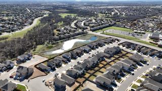 Street view Aerial view of the Village at Northtown by KB Home in Pflugerville, TX, showcasing a scenic community with modern homes and lush greenery.