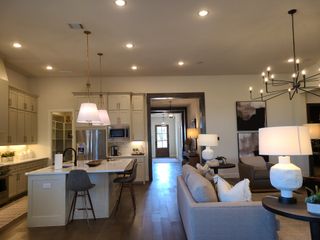 Open-concept living space featuring a sleek kitchen island, elegant lighting, and stylish decor.