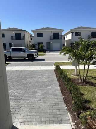 Modern homes with sleek black balconies and manicured lawns in On Alba by Onx Homes (Florida City, FL).