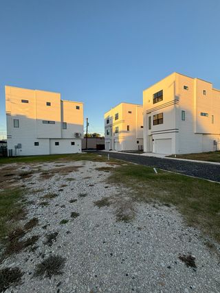 Street view Three contemporary townhomes with geometric designs and private garages, showcasing The Deco by Terramark Urban Homes in San Antonio, TX.