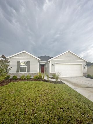 A charming gray home with a tidy lawn in Anabelle Island - Executive Series by KB Home (Green Cove Springs, FL).