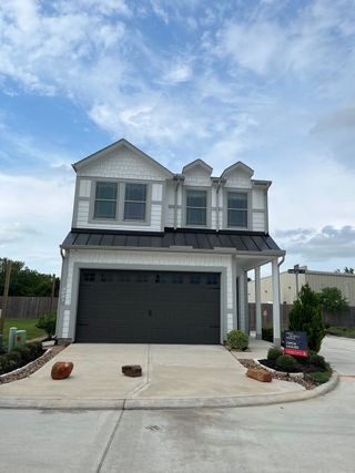 Street view A modern white two-story home with a sleek garage in Cay Landing by First America Homes (Houston, TX).