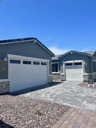 A modern gray home with stone accents and spacious driveway in Estates at Laveen Vistas by Richmond American Homes (Laveen, AZ).