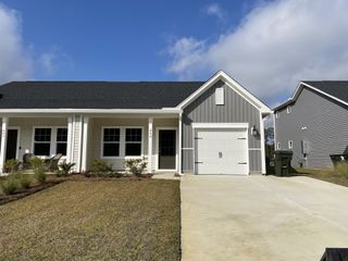 A charming single-story home with modern siding and a tidy lawn in Hammock Walk at Nexton by Ashton Woods (Summerville, SC).