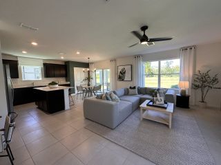 Model Home A spacious family room blending comfort and style, with a statement wood-paneled entertainment wall and expansive backyard views.
