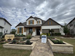 Street view A stunning white brick home with rustic shutters and lush landscaping in Santa Rita Ranch: 40-45ft. lots by Highland Homes (Liberty Hill, TX).
