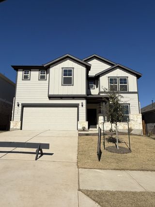 A modern two-story home with clean lines and a spacious driveway in Saddleback at Santa Rita Ranch by Pulte Homes (Liberty Hill, TX).