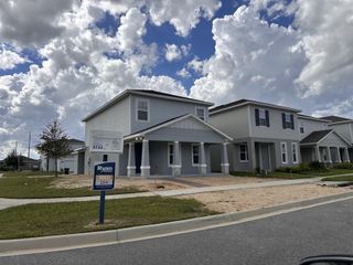 A charming gray home with a covered porch in Parkview Preserve by Ryan Homes, Apopka, FL.