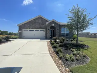 Street view A charming brick home with manicured landscaping in Preserve at Medina by LGI Homes, San Antonio, TX.