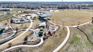 An expansive park with winding paths, playgrounds, and open spaces in Easton Park by Pacesetter Homes (Austin, TX).