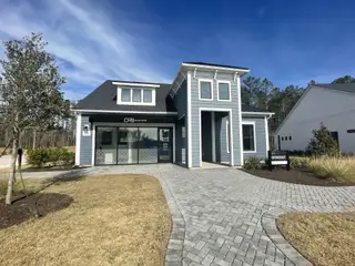 A charming blue home with modern design and landscaped yard in Summerwind Crossing at Lakes of Cane Bay by DRB Elevate (Summerville, SC).
