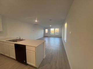 An open-concept living space with sleek flooring, ample natural light, and a modern kitchen island.