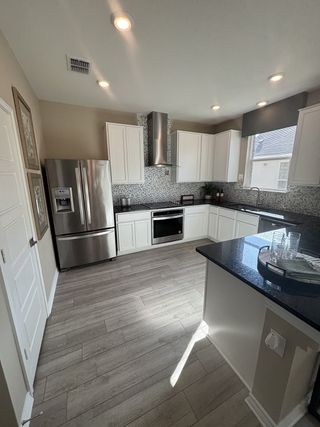 Model Home A modern kitchen featuring stainless steel appliances, sleek cabinetry, and elegant granite countertops.