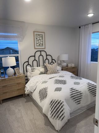 A cozy bedroom featuring modern decor, patterned bedding, and soft lighting, creating a serene and inviting atmosphere.