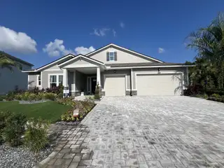 A modern home with a paved driveway and lush landscaping in RiverTown - Meadows by Mattamy Homes (St. Johns, FL).