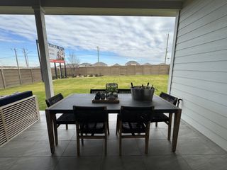 A cozy patio dining area with a sleek table, chairs, and garden view, perfect for outdoor relaxation and entertaining.