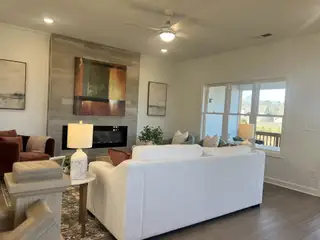 A cozy living room featuring a modern fireplace, elegant artwork, and plush seating bathed in natural light.