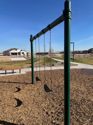 A serene playground with swings and paths in Bentridge – Canyon Series by Landsea Homes (Buckeye, AZ).