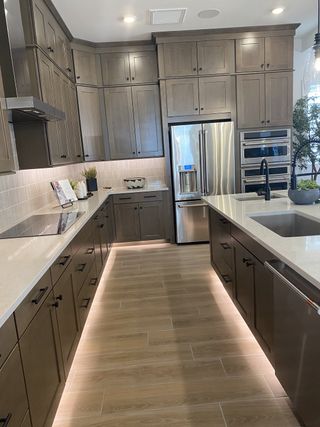 A modern kitchen with sleek wood cabinets, stainless steel appliances, and ambient lighting adds warmth and style.