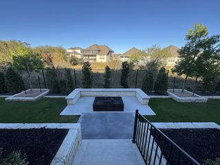 A well-manicured backyard features a sleek fire pit and lush greenery, creating a serene outdoor retreat.
