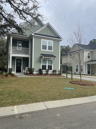 Charming green two-story home with a porch in Pineland Village by Center Park Homes (Summerville, SC).