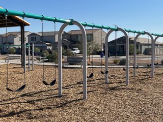 Community Amenities Charming playground with swings in Maple at North Copper Canyon by Courtland Communities, Surprise, AZ.