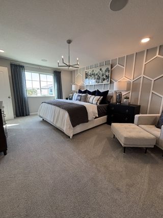 Model Home A luxurious primary bedroom with exposed beams, warm wood flooring, and elegant decor in Eden at Crossprairie by M/I Homes (St. Cloud, FL).