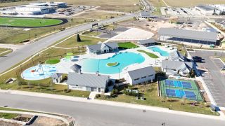 Aerial view of a vibrant pool and sports area in Santa Rita Ranch by CastleRock Communities (Liberty Hill, TX).